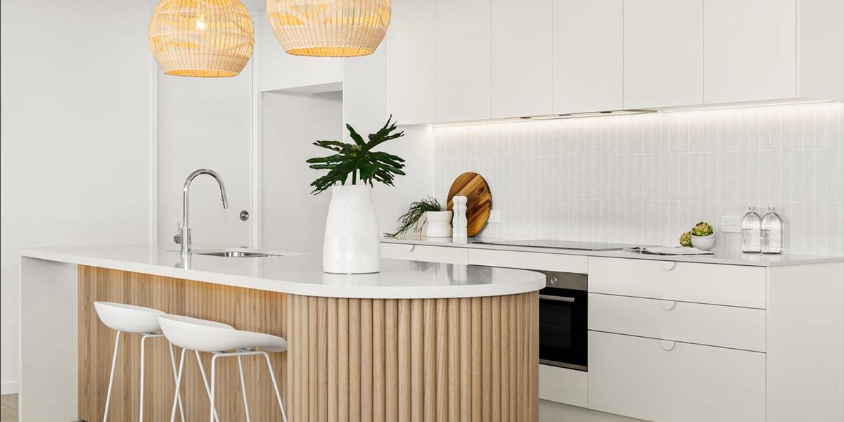white and wooden kitchen with curved island bench